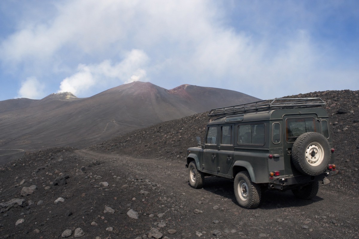 A 4x4 vehicle on Mount Etna's upper volcanic terrain, one of the extras that raise the cost of a Mount Etna tour